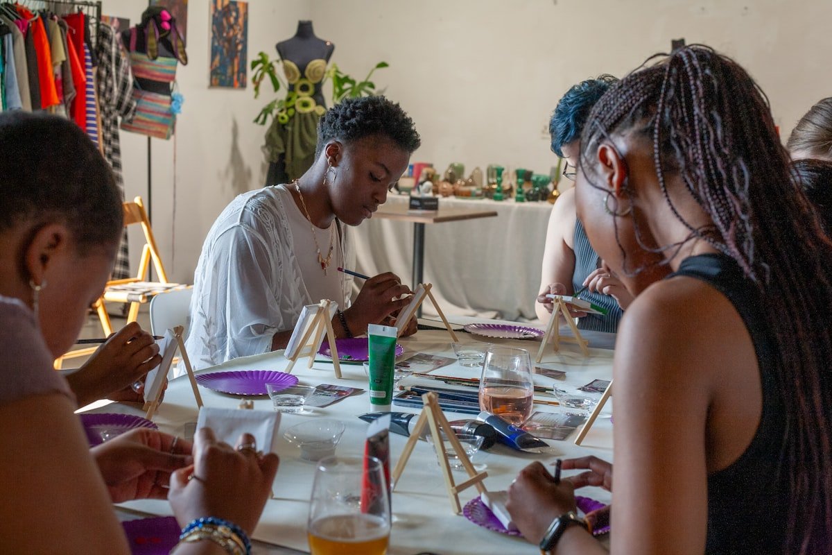 Young people painting and creating art together at a table